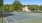 a tennis court with a house in the background